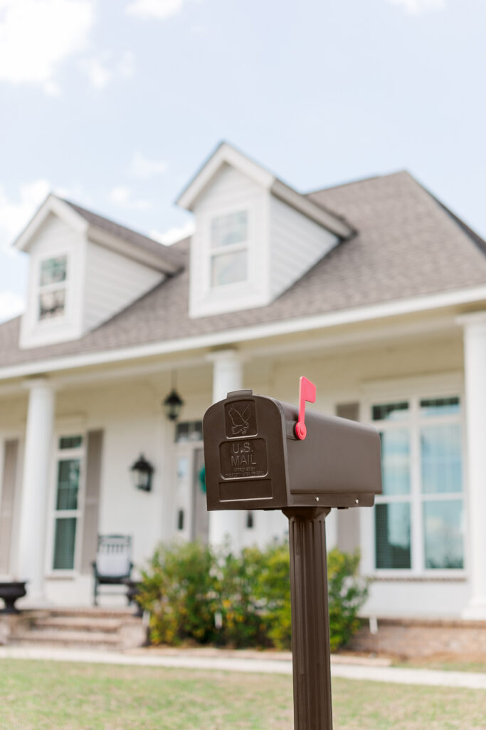 Manufacturer photograph of Harrison bronze mailbox installed outside a home