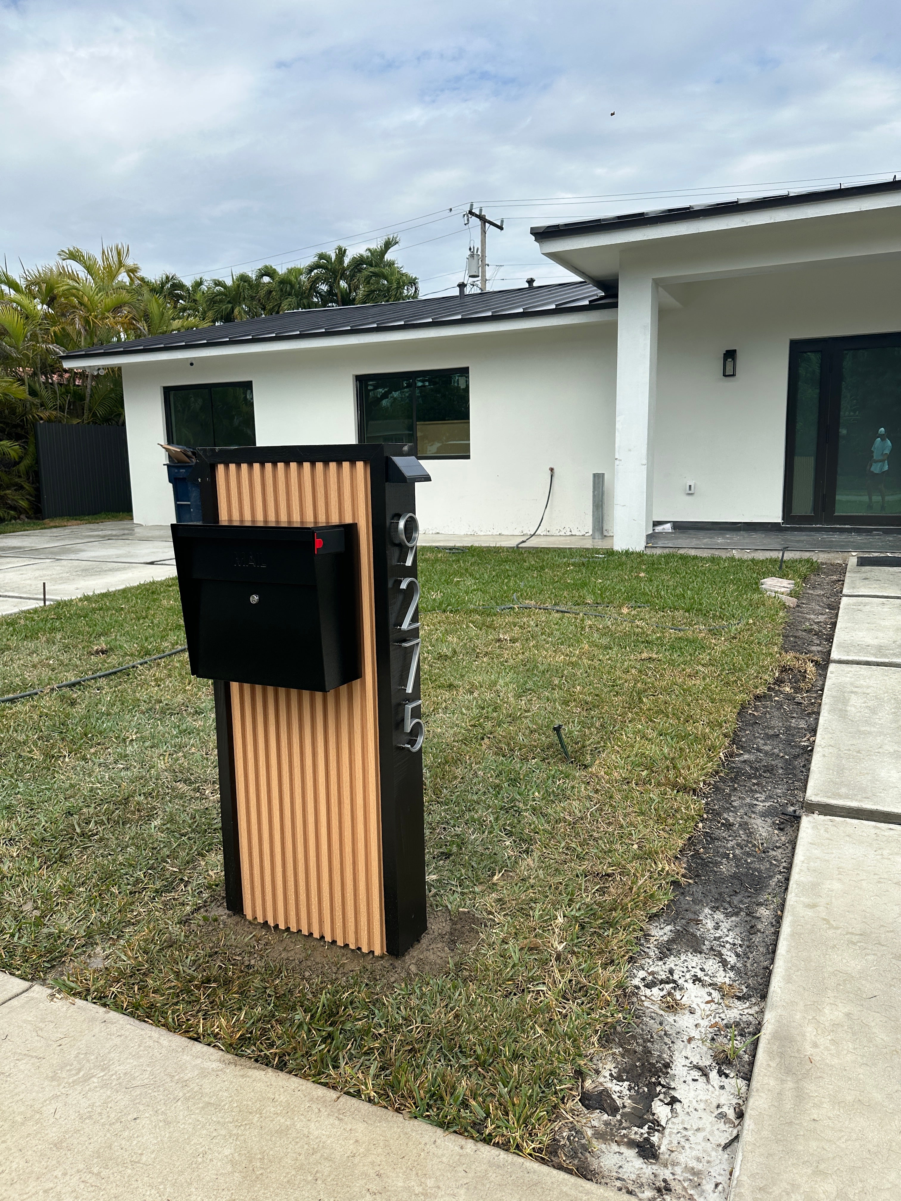 Modern house exterior with a driveway and grass area.